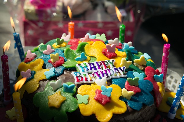 Torta di compleanno colorata con candele scintillanti